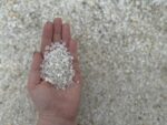 Белая плосковидная мраморная крошка фракции 2–5 мм в ладони